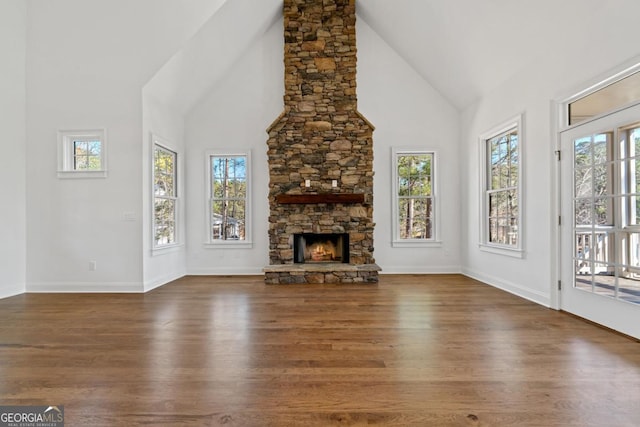 unfurnished living room with a fireplace, dark hardwood / wood-style flooring, and high vaulted ceiling