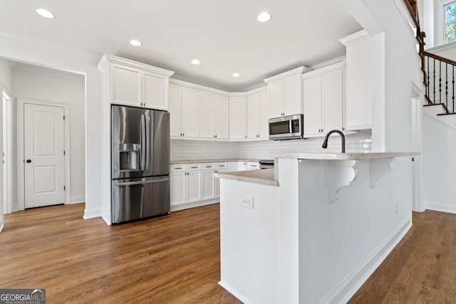 kitchen featuring stainless steel appliances, dark wood-type flooring, and white cabinets