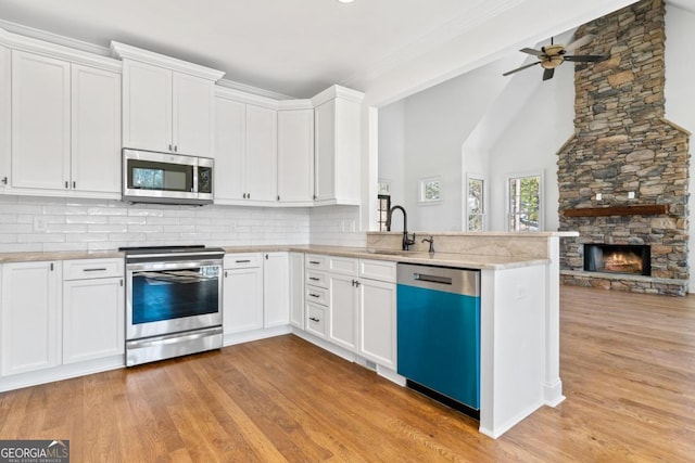 kitchen with white cabinetry, appliances with stainless steel finishes, sink, and backsplash