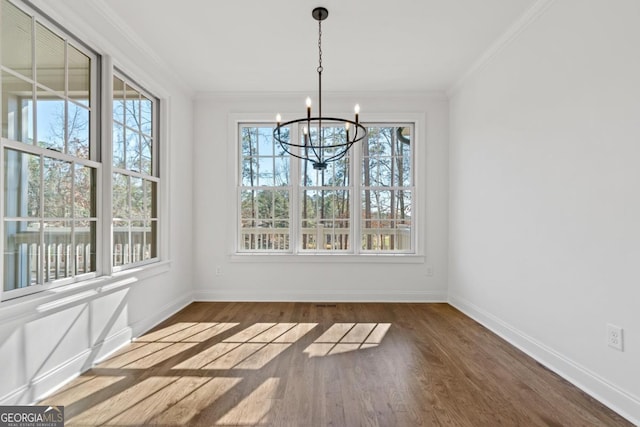 unfurnished dining area with crown molding, plenty of natural light, dark hardwood / wood-style floors, and a notable chandelier