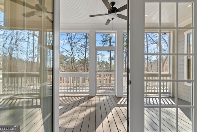 unfurnished sunroom with ceiling fan