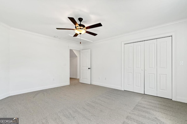 unfurnished bedroom featuring ceiling fan, ornamental molding, a closet, and light carpet