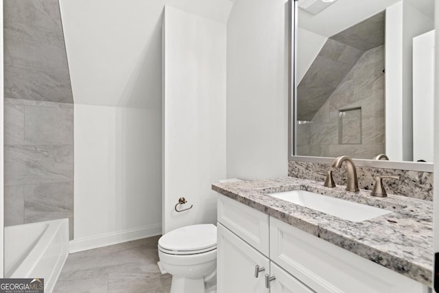 bathroom with vanity, vaulted ceiling, and toilet