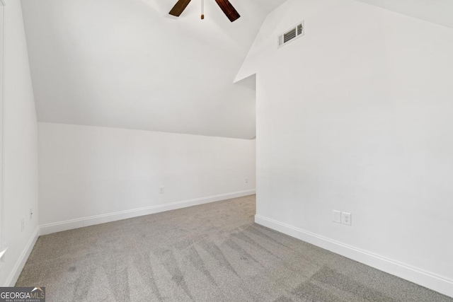 additional living space with vaulted ceiling, light colored carpet, and ceiling fan