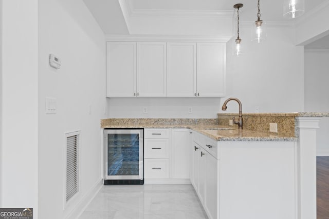 kitchen featuring decorative light fixtures, kitchen peninsula, beverage cooler, light stone countertops, and white cabinets