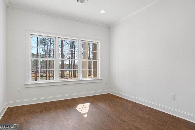 empty room with dark hardwood / wood-style flooring and ornamental molding