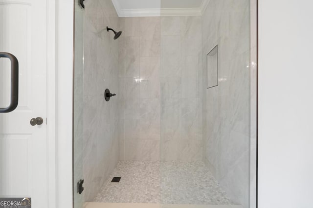 bathroom featuring a tile shower and crown molding