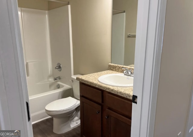 bathroom with toilet, tub / shower combination, wood finished floors, and vanity