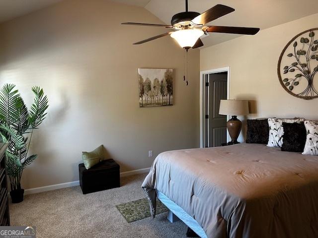 carpeted bedroom featuring ceiling fan and vaulted ceiling