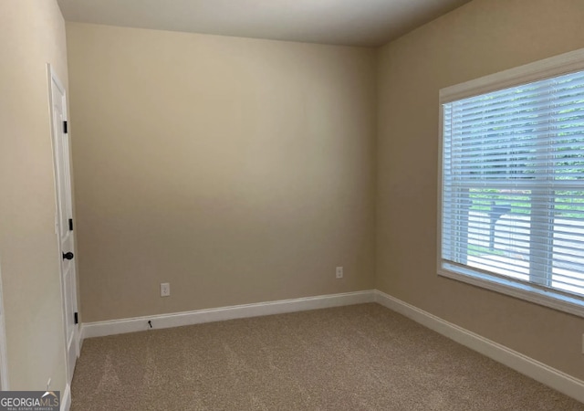 spare room with light carpet and baseboards