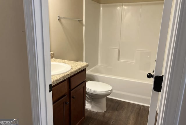 bathroom with toilet,  shower combination, wood finished floors, and vanity