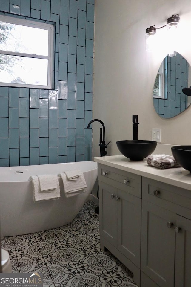 bathroom with vanity, tile patterned flooring, and a bathtub