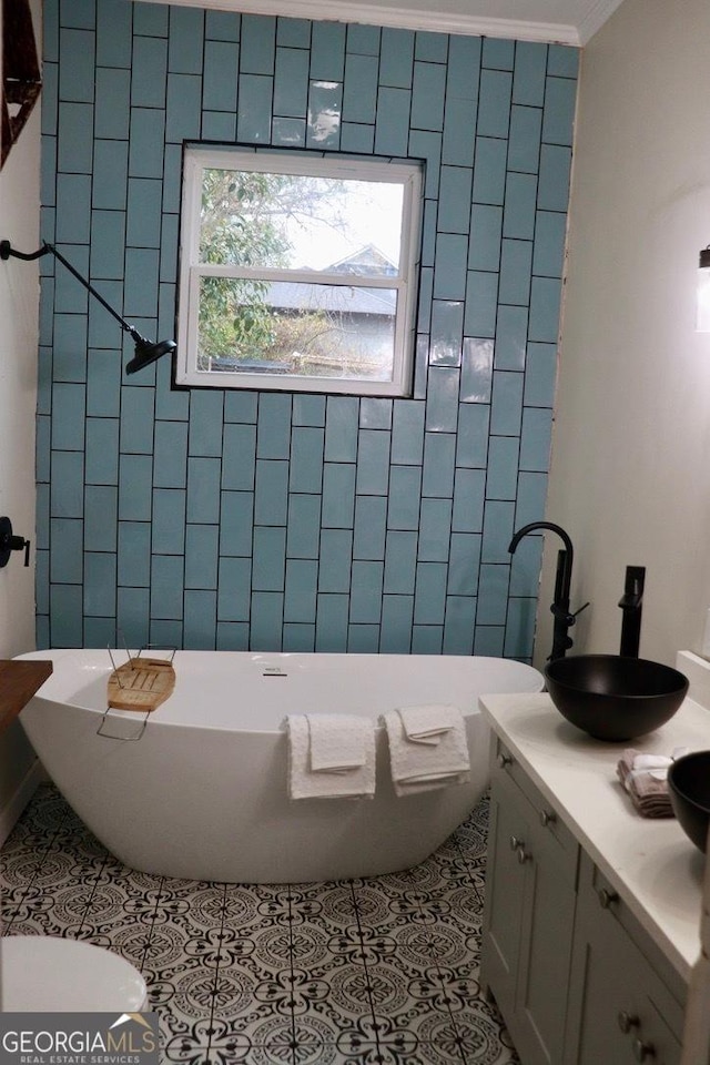 bathroom with crown molding, tile patterned floors, a bath, and vanity