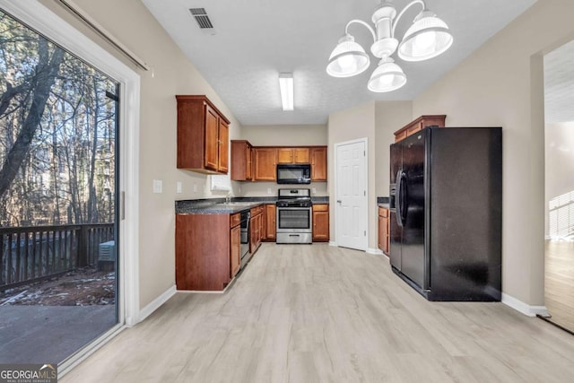 kitchen with light wood-type flooring, a chandelier, sink, and black appliances