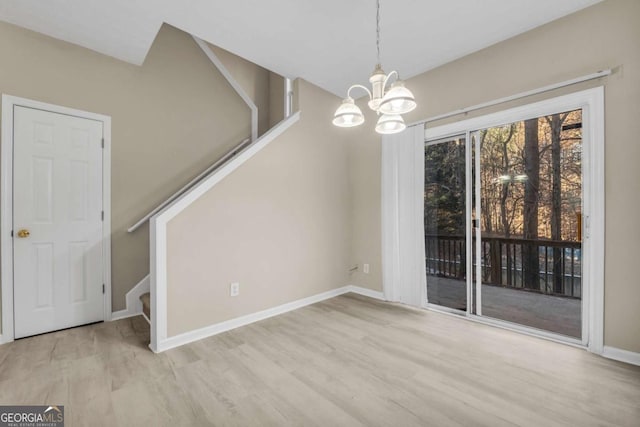 unfurnished dining area featuring an inviting chandelier and light hardwood / wood-style floors