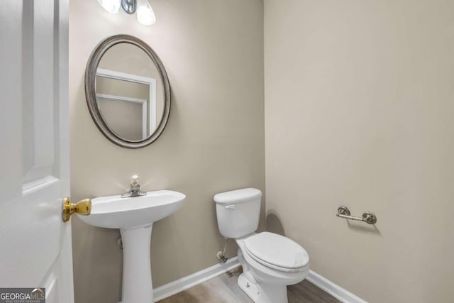 bathroom with wood-type flooring and toilet