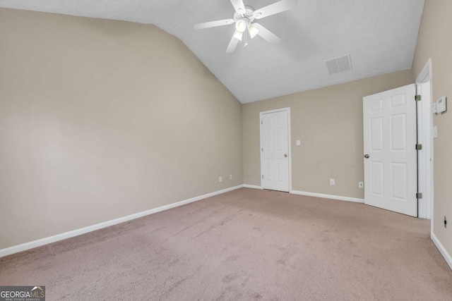 unfurnished room with ceiling fan, vaulted ceiling, and light carpet