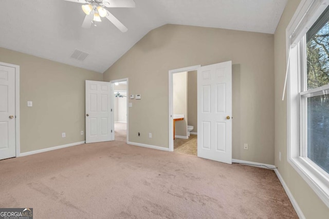 unfurnished bedroom featuring lofted ceiling, light colored carpet, ceiling fan, and ensuite bath