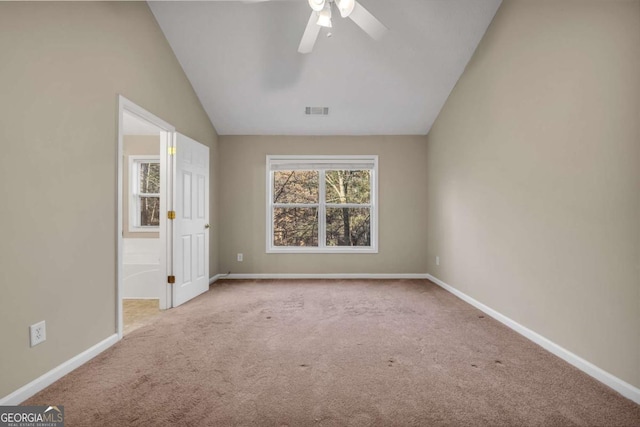 carpeted spare room featuring ceiling fan and lofted ceiling