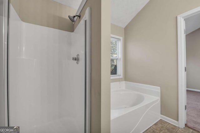 bathroom with plus walk in shower, lofted ceiling, and a textured ceiling