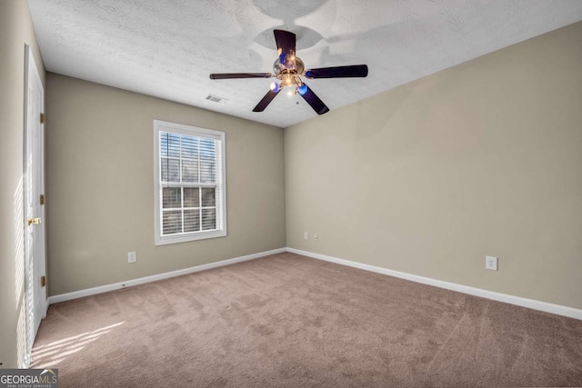 carpeted spare room with ceiling fan and a textured ceiling