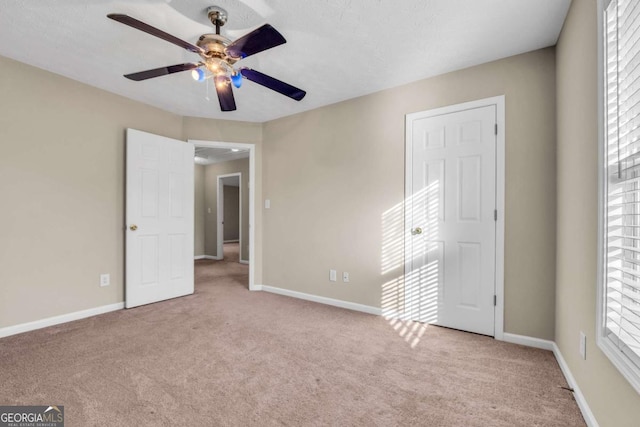 unfurnished bedroom with light carpet and ceiling fan