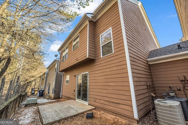 rear view of property with cooling unit and a patio