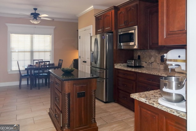 kitchen with ceiling fan, appliances with stainless steel finishes, light stone counters, tasteful backsplash, and ornamental molding