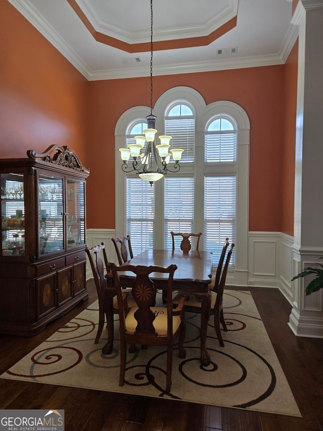 dining space featuring ornamental molding, dark hardwood / wood-style flooring, a chandelier, and a raised ceiling