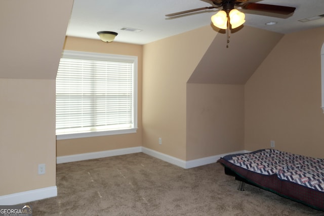 unfurnished bedroom featuring light carpet, vaulted ceiling, and ceiling fan