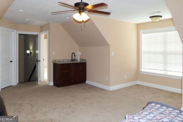 additional living space with light colored carpet and ceiling fan