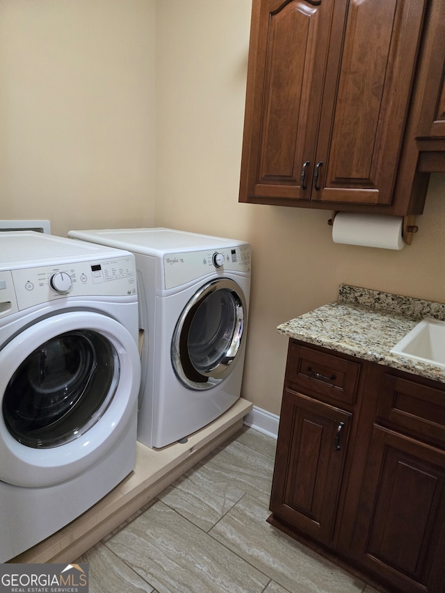 washroom featuring cabinets, sink, light hardwood / wood-style floors, and independent washer and dryer