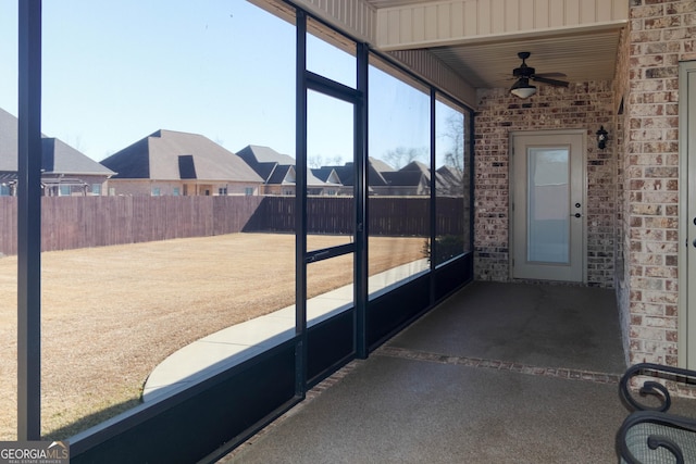 unfurnished sunroom with ceiling fan