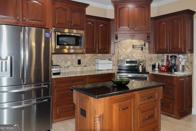 kitchen with tasteful backsplash, dark stone countertops, ornamental molding, a kitchen island, and stainless steel appliances