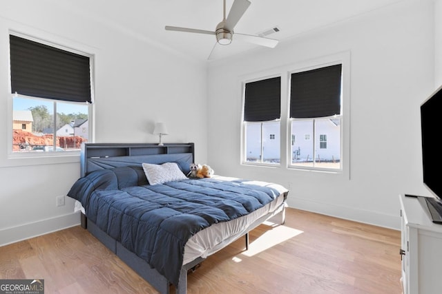 bedroom with light hardwood / wood-style flooring and ceiling fan