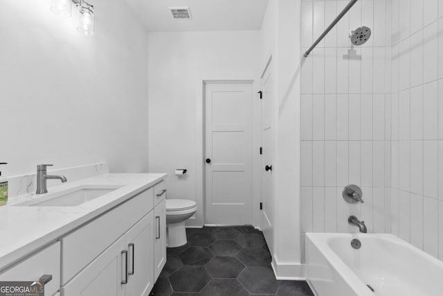 full bathroom with vanity, tile patterned flooring, toilet, and tiled shower / bath