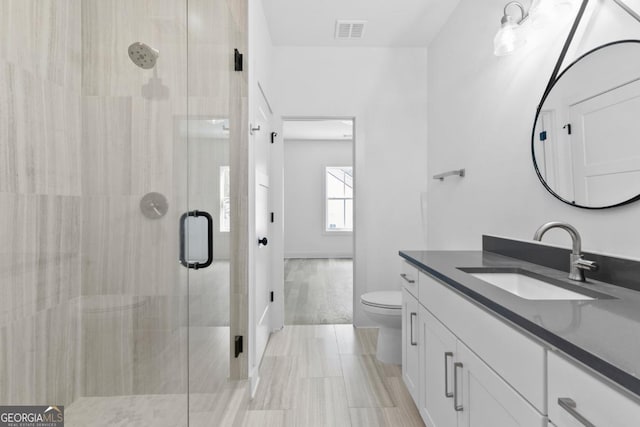 bathroom featuring vanity, toilet, and walk in shower