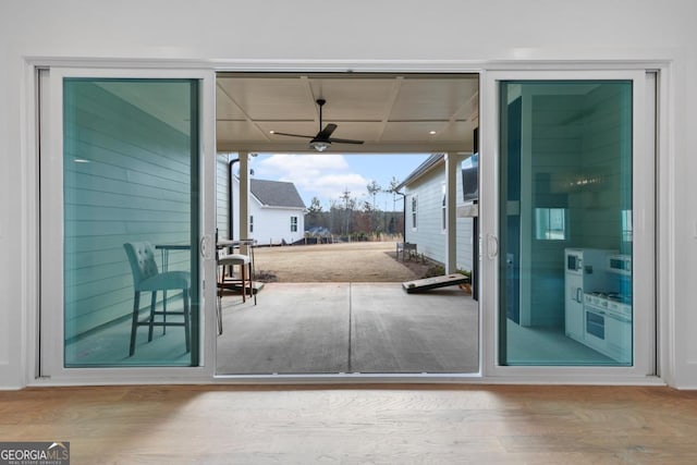 doorway to outside with hardwood / wood-style flooring and ceiling fan