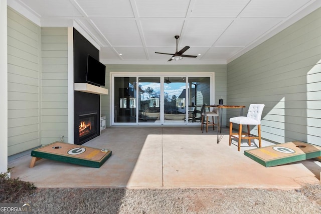 view of patio / terrace with ceiling fan and a fireplace