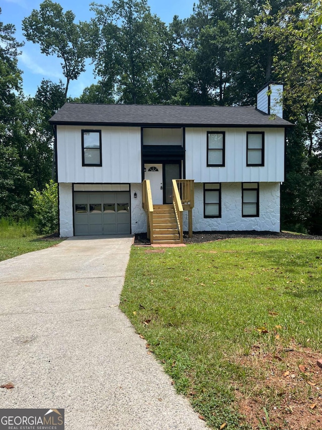 split foyer home featuring a garage and a front yard