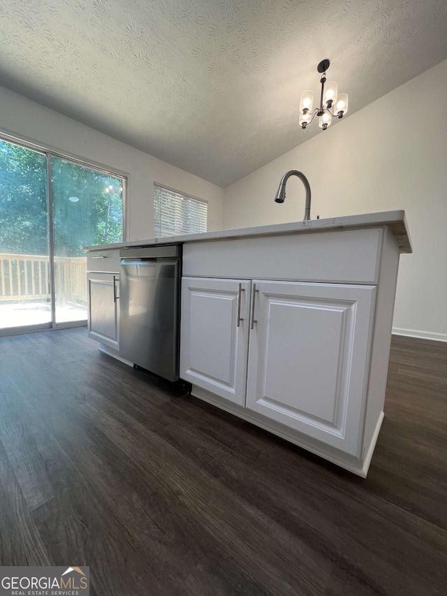 kitchen with white cabinetry, stainless steel dishwasher, hanging light fixtures, and a textured ceiling