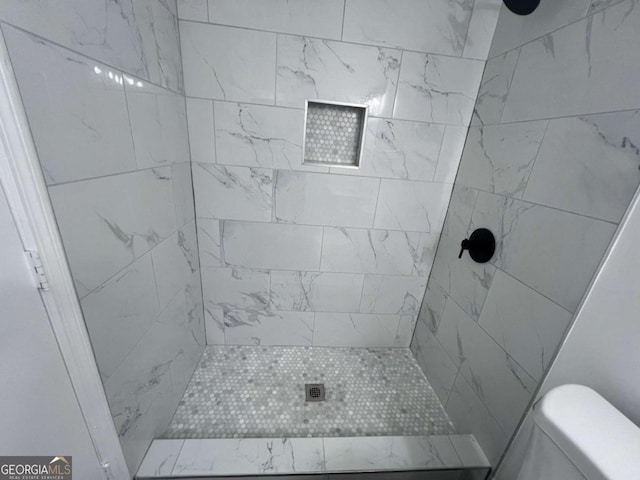 bathroom featuring a tile shower