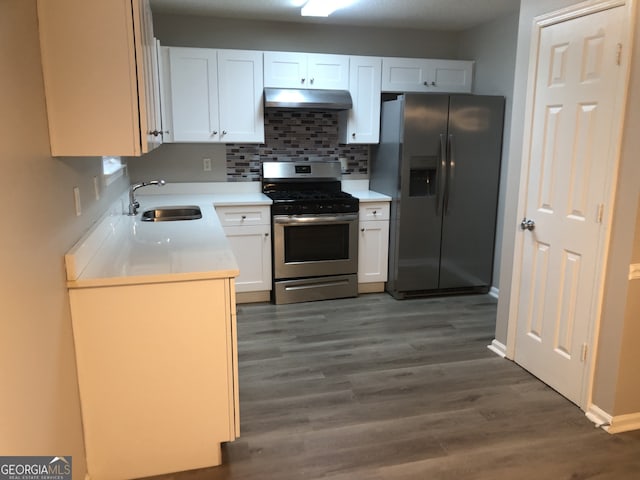 kitchen featuring appliances with stainless steel finishes, dark hardwood / wood-style floors, white cabinetry, sink, and backsplash