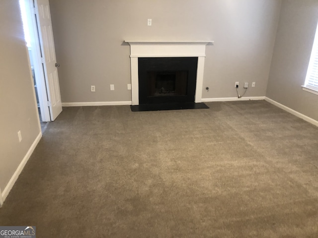 unfurnished living room featuring dark carpet