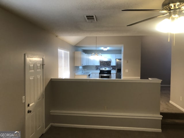 kitchen with sink, appliances with stainless steel finishes, white cabinetry, tasteful backsplash, and kitchen peninsula