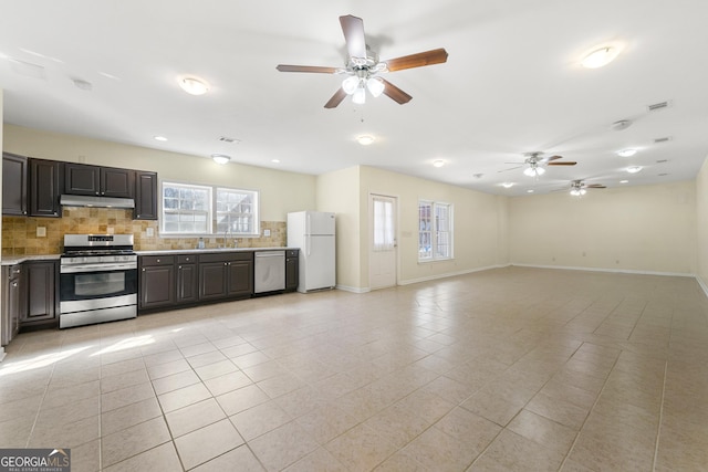 kitchen with tasteful backsplash, dark brown cabinets, light tile patterned flooring, and appliances with stainless steel finishes