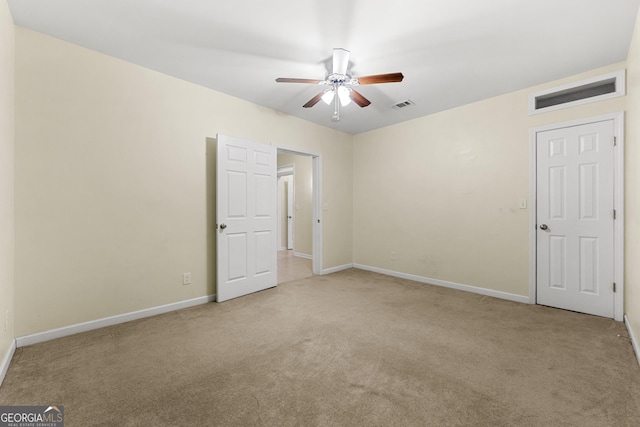 carpeted spare room featuring ceiling fan