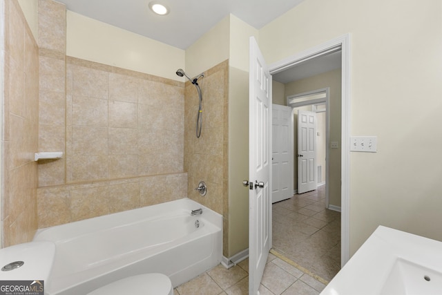 bathroom featuring tile patterned flooring, tiled shower / bath combo, and toilet