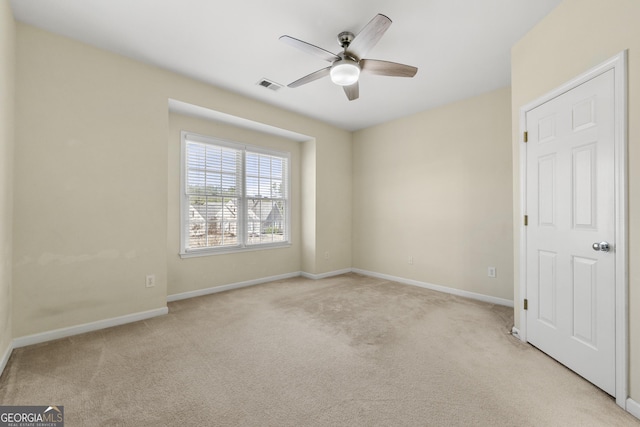 unfurnished room with light colored carpet and ceiling fan