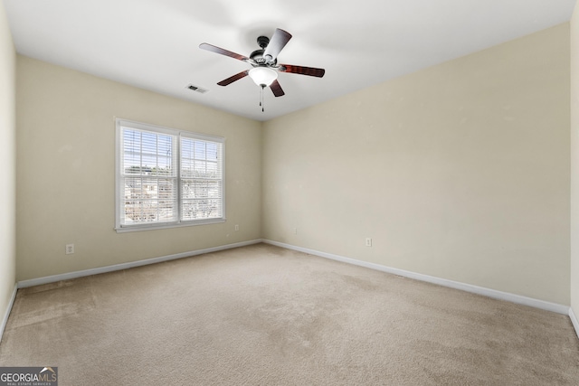 spare room featuring light colored carpet and ceiling fan